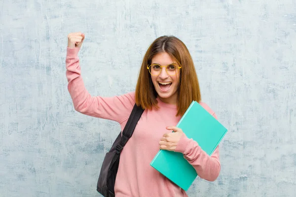 興奮して幸せそして驚くべき勝者のように興奮して叫んでいる若い学生の女性グランジウォールの背景を祝う — ストック写真