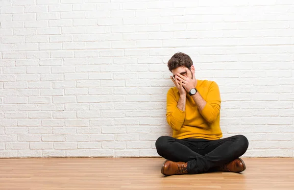 Ung Stilig Man Sitter Hemmaplan Mot Tegelvägg Konsistens — Stockfoto