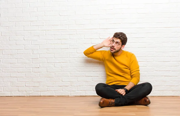 Junger Gutaussehender Mann Sitzt Auf Dem Fußboden Vor Einer Ziegelwand — Stockfoto