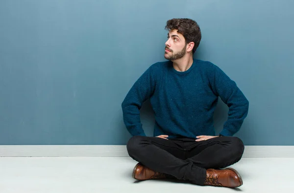 Νεαρός Όμορφος Άνδρας Κάθεται Στο Πάτωμα Αισθάνεται Σύγχυση Πλήρης Αμφιβολίες — Φωτογραφία Αρχείου