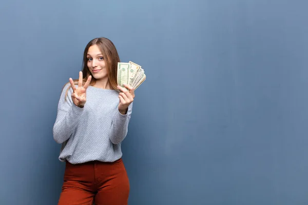 Νεαρή Όμορφη Γυναίκα Χαρτονομίσματα Δολαρίου Στον Μπλε Τοίχο Ένα Χώρο — Φωτογραφία Αρχείου
