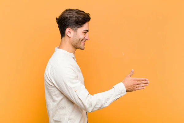 Junger Gutaussehender Mann Lächelt Begrüßt Sie Und Reicht Ihnen Die — Stockfoto