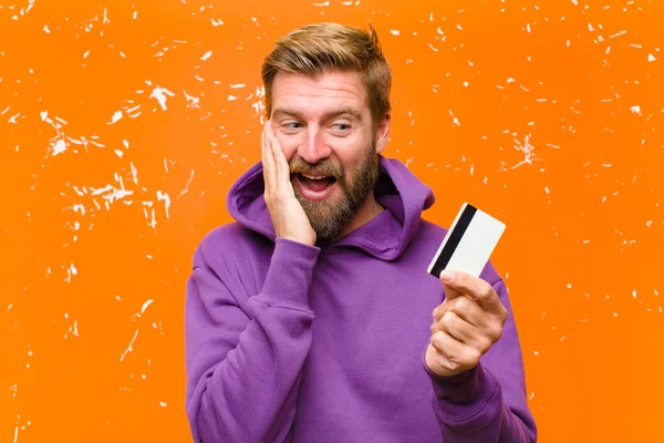 Junger Blonder Mann Mit Kreditkarte Trägt Lila Kapuzenpullover Gegen Beschädigte — Stockfoto