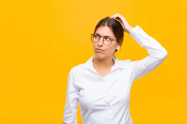 Young Businesswoman Feeling Puzzled Confused Scratching Head Looking Side Orange — Stock Photo, Image