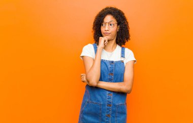 Genç, güzel, siyah bir kadın. Düşünüyor, kuşkulu ve kafası karışık. Farklı seçenekleri var.