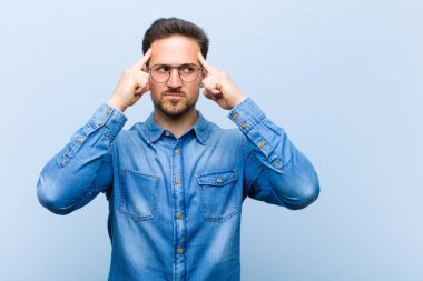 Genç yakışıklı bir adam konsantre olmuş ve bir fikir üzerinde kafa yoruyor, bir meydan okumaya ya da soruna bir çözüm hayal ediyor.