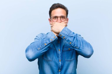 Şok olmuş, şaşırmış bir ifadeyle ağzı kapalı genç yakışıklı bir adam sır saklıyor ya da 