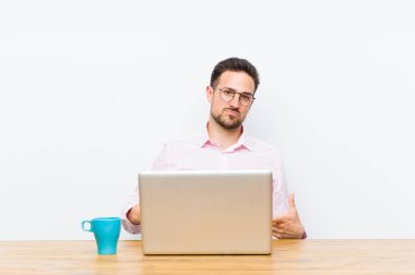 Genç yakışıklı iş adamı gururlu, kibirli, mutlu, şaşırmış ve tatmin olmuş görünüyor, kendini gösteriyor, kazanan gibi hissediyor.