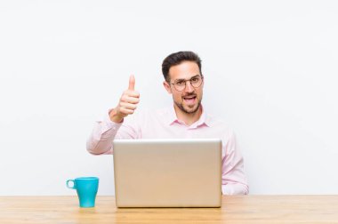 Genç yakışıklı iş adamı gururlu, kaygısız, kendinden emin ve mutlu, olumlu gülümsüyor.