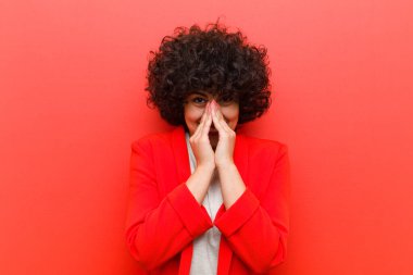 Genç, güzel afro kadın mutlu, neşeli, şanslı ve şaşkın görünüyor iki eliyle ağzını kapatıyor.