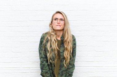 Genç, sarışın bir kadın aptal ve komik görünüyor. Şaşı bakışlarıyla, şakalar yapıyor ve duvarın arkasında takılıyor.