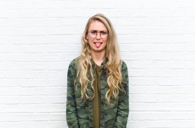 Genç sarışın kadın tiksinmiş ve rahatsız olmuş hissediyor. Dilini dışarı çıkarıyor. Çirkin ve iğrenç bir şeyden hoşlanmıyor.