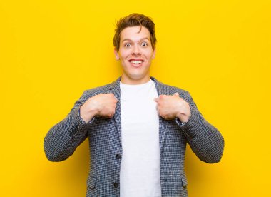 Genç kızıl saçlı adam mutlu, şaşırmış ve gururlu hissediyordu. Heyecanlı, şaşkın bakışlarıyla turuncu arka plana bakıyordu.