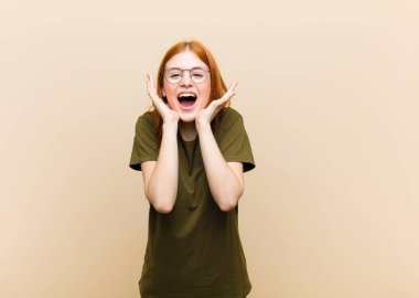 Genç kızıl saçlı güzel kadın şok olmuş ve heyecanlı, gülüyor, şaşırmış ve mutlu çünkü beklenmedik bir sürpriz