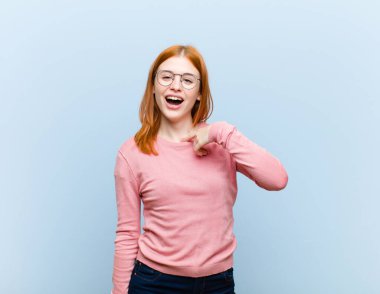 Genç kızıl saçlı güzel bir kadın. Mutlu, gururlu ve şaşırmış görünüyor. Neşeli bir şekilde kendini gösteriyor.