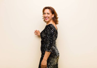 Orta yaşlı güzel bir kadın izole edilmiş ve düz arkaplanda poz veriyor.