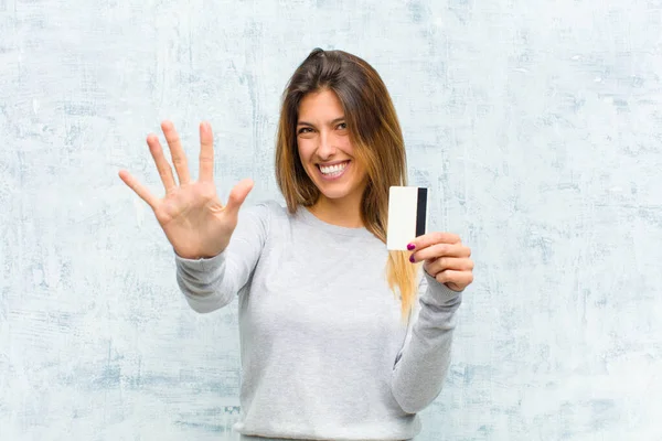 Giovane Bella Donna Con Una Carta Credito Contro Muro Grunge — Foto Stock