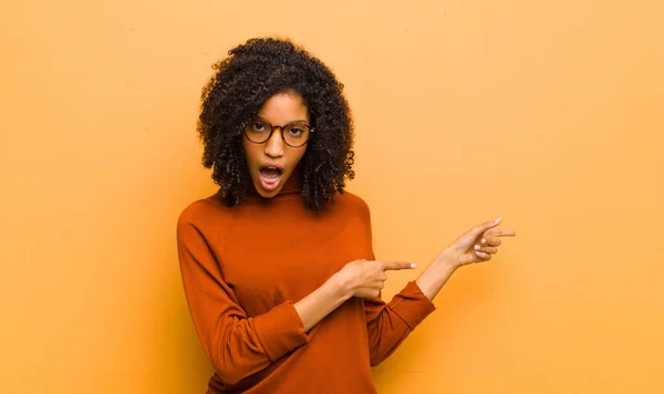 Joven Bonita Mujer Negra Sintiéndose Sorprendida Sorprendida Apuntando Copiar Espacio —  Fotos de Stock