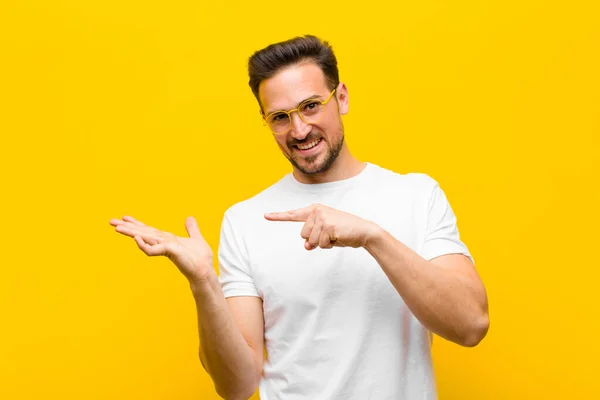 Jonge Knappe Man Lachend Vrolijk Wijzend Naar Kopieer Ruimte Palm — Stockfoto