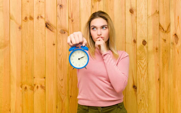 Joven Mujer Rubia Bonita Con Reloj Despertador Contra Pared Madera — Foto de Stock