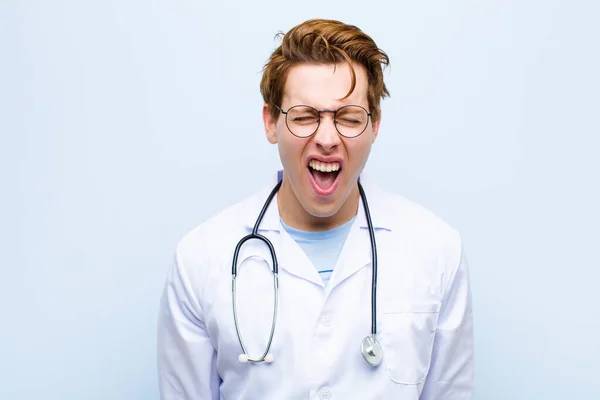 Mladý Rudý Lékař Křičí Agresivně Vypadá Velmi Rozzlobeně Frustrovaně Rozhořčeně — Stock fotografie