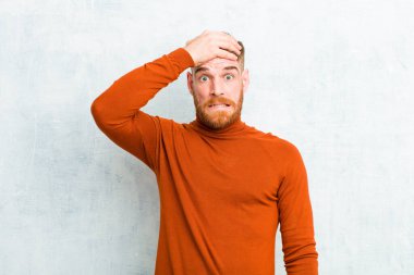 Kaplumbağa boynu takan genç kızıl adam unutulmuş bir mühlet yüzünden panikliyor, stresli hissediyor, beton duvara karşı bir pisliği veya hatayı örtbas etmek zorunda kalıyor.