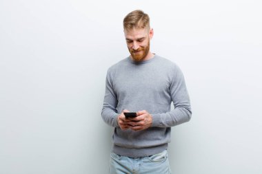 beyaz arka plan karşı bir akıllı telefon ile genç kırmızı kafa adam