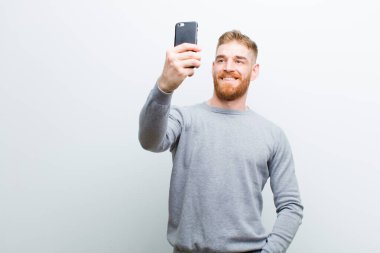 beyaz arka plan karşı bir akıllı telefon ile genç kırmızı kafa adam