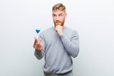 beyaz arka plan karşı bir kum saat zamanlayıcı ile genç kırmızı kafa adam