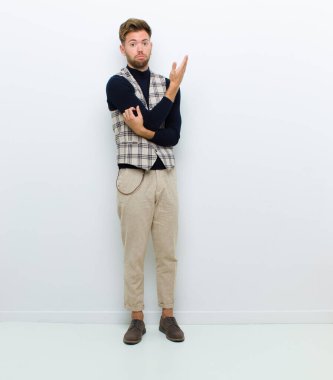 Genç bedenci kendini şaşkın ve cahil hissediyor. Beyaz arka planda şüpheli bir açıklama ya da düşünce var mı diye merak ediyor.