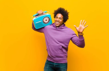 Turuncu B 'ye karşı klasik radyosu olan genç Afro-Amerikan bir adam.