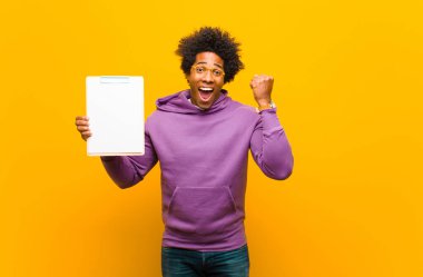 Genç Afrikalı Amerikalı adam turuncu arka plana karşı