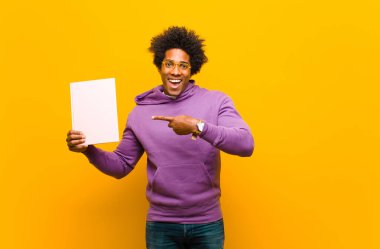 Genç Afrikalı Amerikalı adam turuncu arka plana karşı