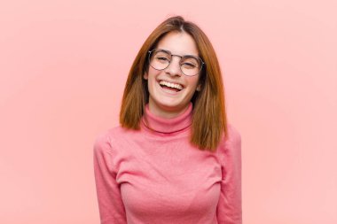 Büyük, dostane, kaygısız bir gülümsemesi olan genç ve güzel bir kadın. Olumlu, rahat ve mutlu görünüyor. Pembe arka planda takılıyor.