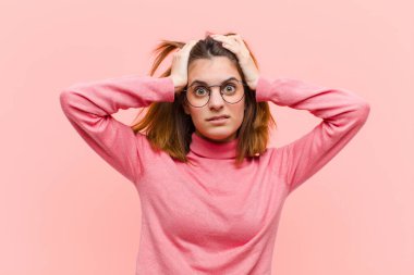 Genç ve güzel bir kadın hayal kırıklığına uğramış ve sıkılmış hissediyor, başarısızlıktan bıkmış ve bıkmış, pembe arka plana karşı sıkıcı, sıkıcı görevlerden bıkmış