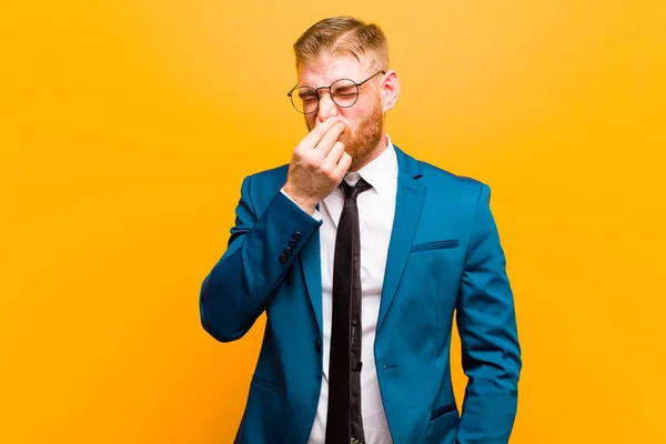 Молодой Рыжеволосый Бизнесмен Чувствует Отвращение Держа Нос Избежать Неприятного Запаха — стоковое фото