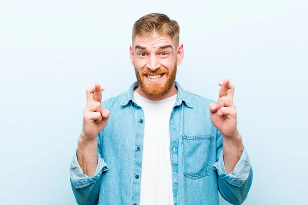 Joven Cabeza Roja Hombre Sonriendo Ansiosamente Cruzando Ambos Dedos Sintiéndose —  Fotos de Stock