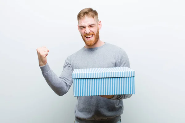 Mladý Červený Muž Který Drží Dárkovou Schránku Bílém Pozadí — Stock fotografie