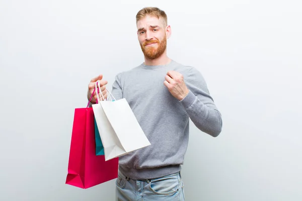 Jovem Homem Cabeça Vermelha Com Sacos Compras Contra Fundo Branco — Fotografia de Stock