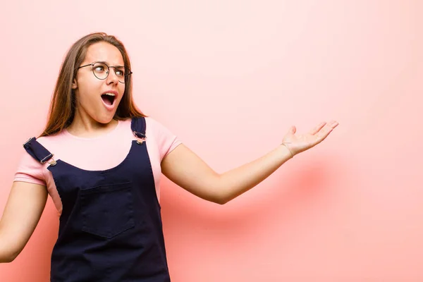 young  woman performing opera or singing at a concert or show, feeling romantic, artistic and passionate against pink background