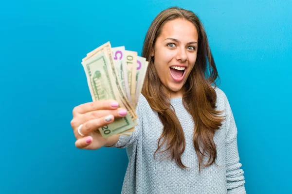 Νεαρή γυναίκα με λογαριασμούς σε μπλε φόντο — Φωτογραφία Αρχείου