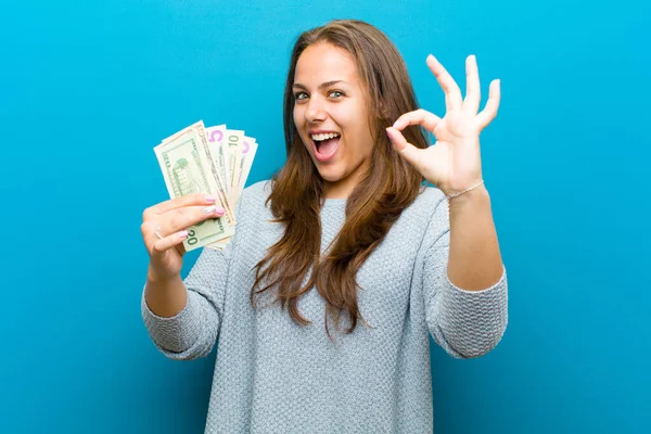Jonge vrouw met rekeningen tegen blauwe achtergrond — Stockfoto