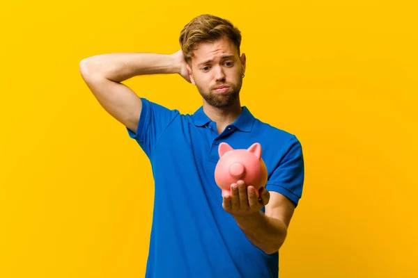 Joven Con Una Alcancía Sobre Fondo Naranja — Foto de Stock