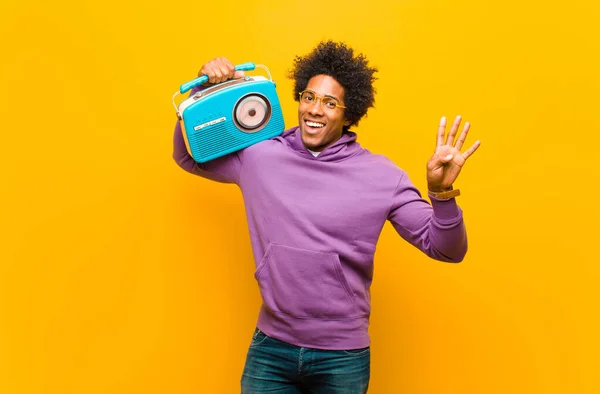 Νεαρός αφροαμερικάνος με ένα vintage ραδιόφωνο κατά πορτοκαλί b — Φωτογραφία Αρχείου