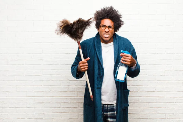 Młody czarny człowiek sprzątanie z czysty produkt — Zdjęcie stockowe