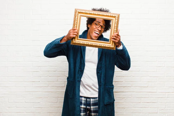 Young black man with a baroque frame at home — ストック写真