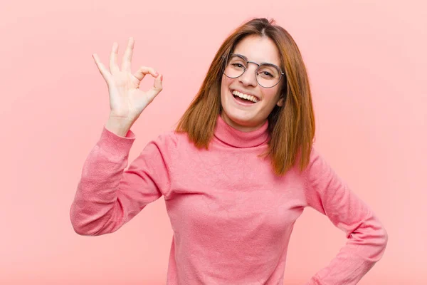 若い可愛い女性は成功して満足してる口を大きく開けたまま笑顔でピンクの背景に手でサインをして — ストック写真