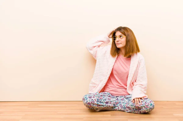 Νεαρή Γυναίκα Φορώντας Πιτζάμες Κάθεται Στο Σπίτι Αισθάνεται Μπερδεμένος Και — Φωτογραφία Αρχείου