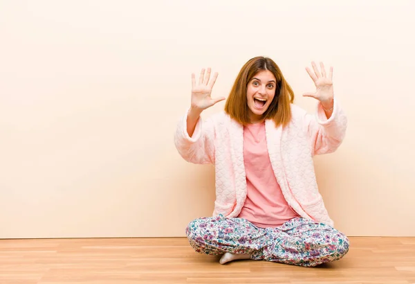 Jeune Femme Pyjama Assis Maison Souriant Regardant Amical Montrant Numéro — Photo