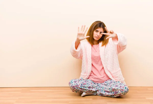 Νεαρή Γυναίκα Φορώντας Πιτζάμες Κάθεται Στο Σπίτι Χαμογελώντας Και Αναζητούν — Φωτογραφία Αρχείου